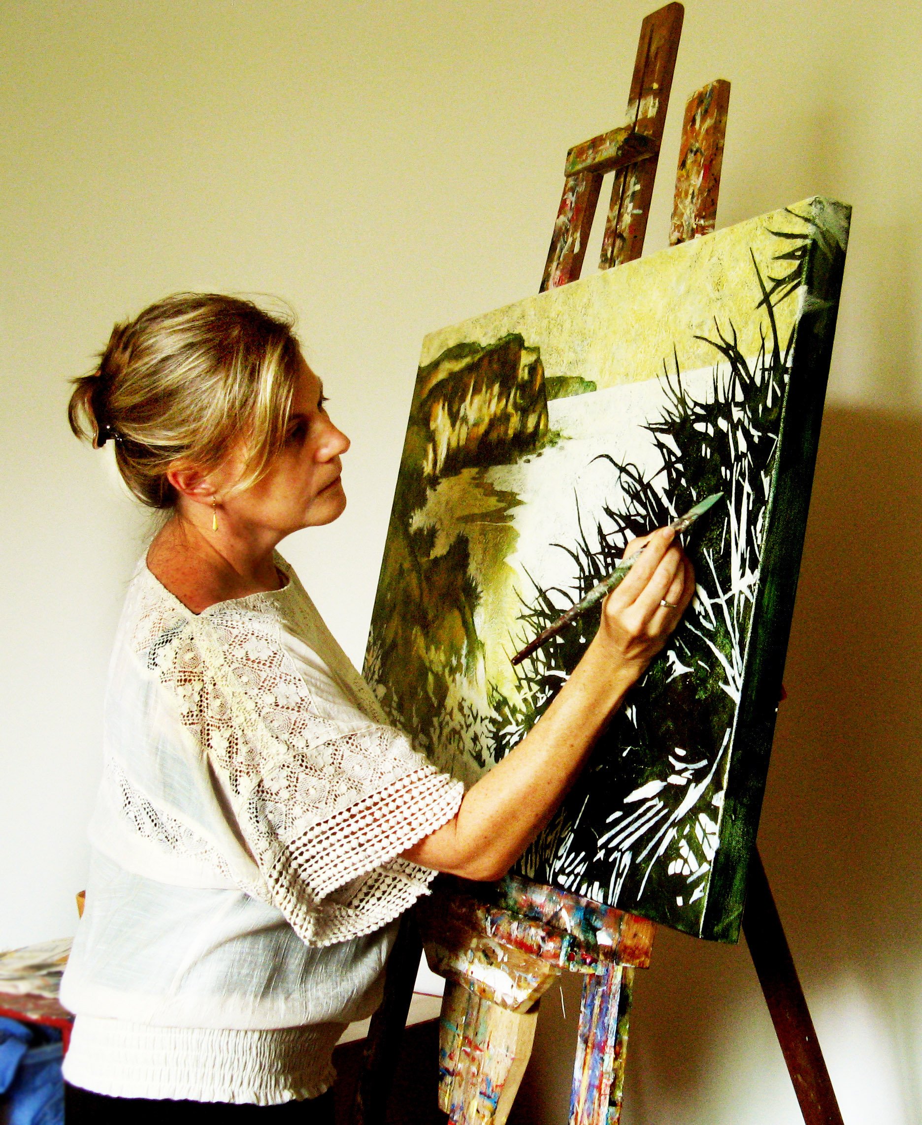 Artist Karyn Fendley painting a landscape on canvas