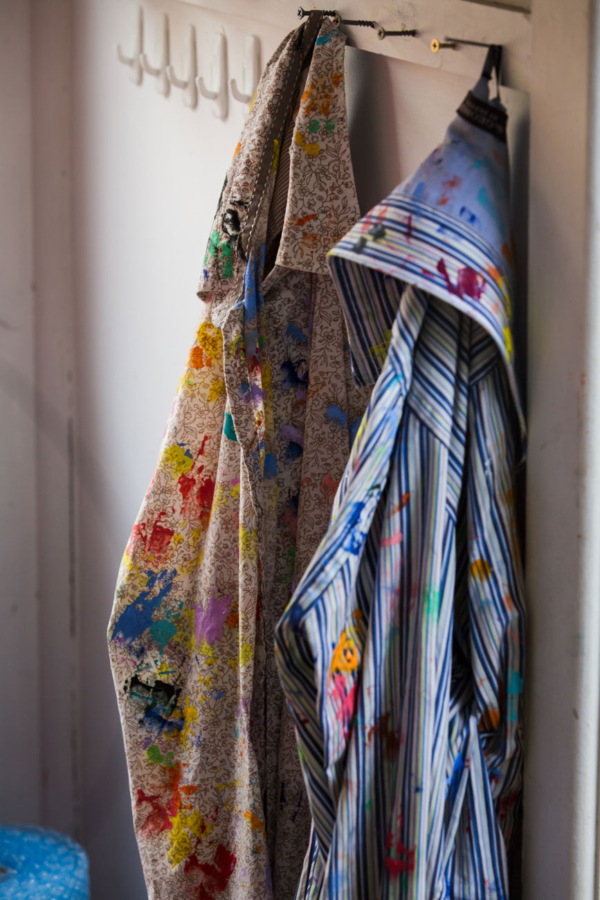 Paint-covered shirts hanging in the studio