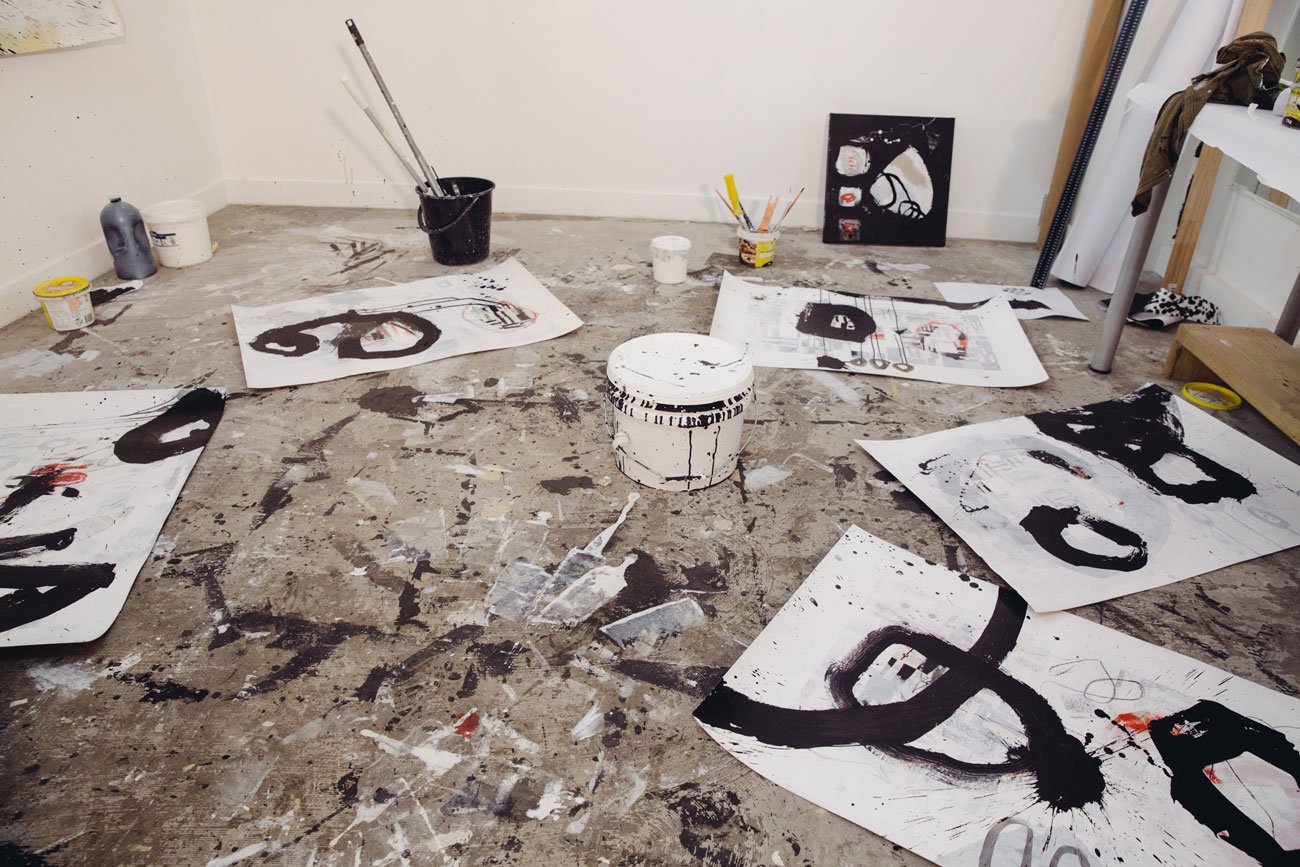 paintings scattered on paint-splattered floor