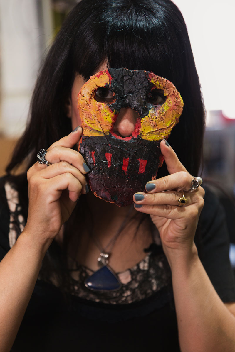 Silvia holding up a mask her kids made