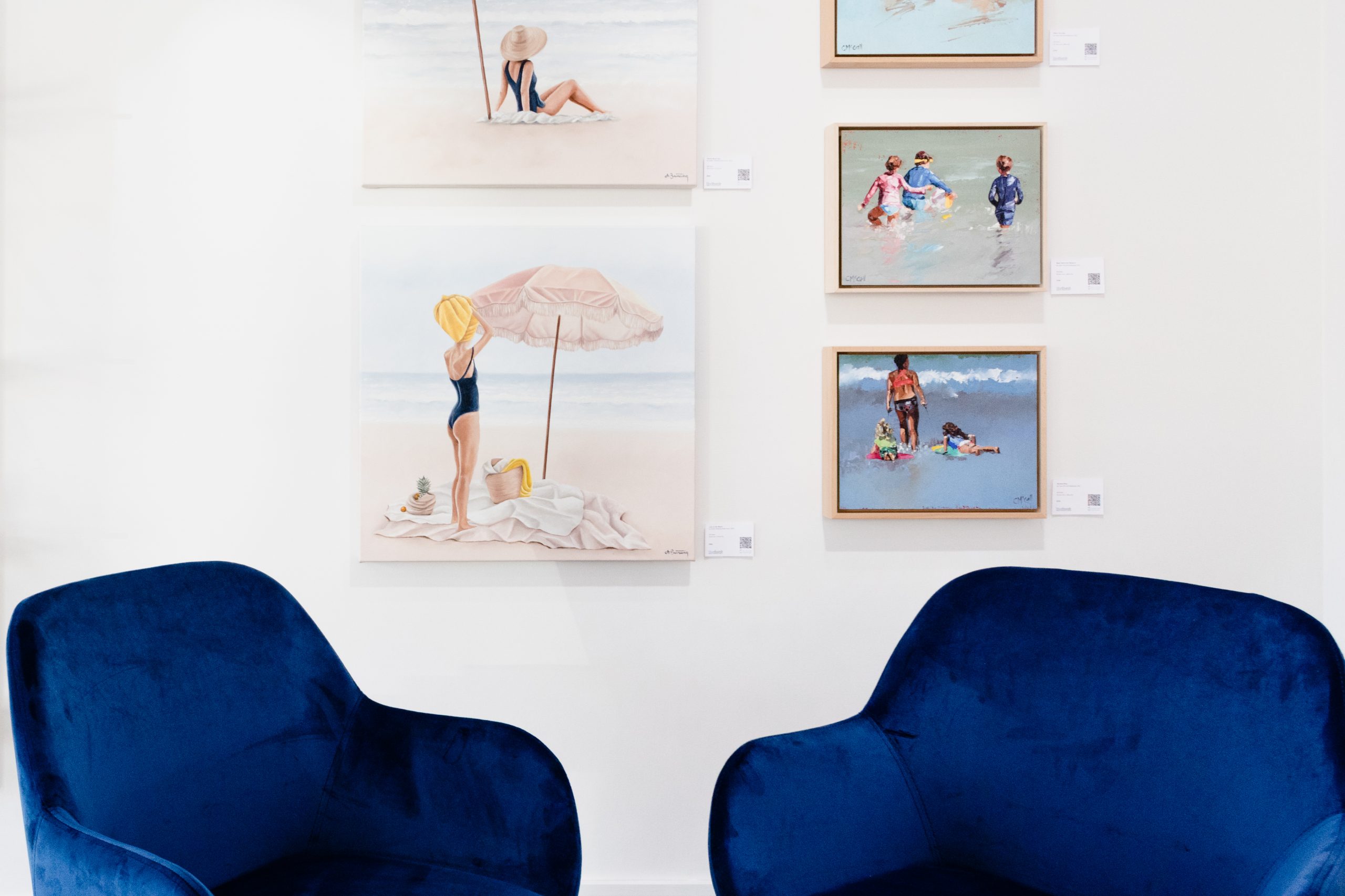 Instant Bluethumb payment methods. Photo of 2 blue chairs in front of pastel colour beach scene artworks.