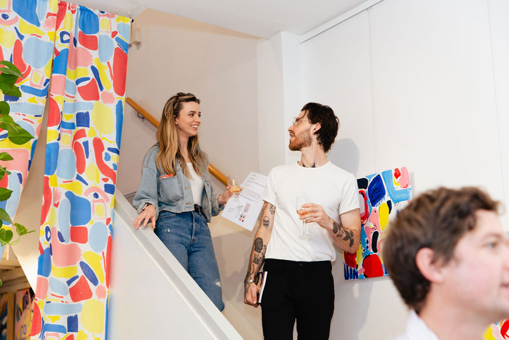 VIP guests smiling on the stairs at Feeling Colours Exhibition