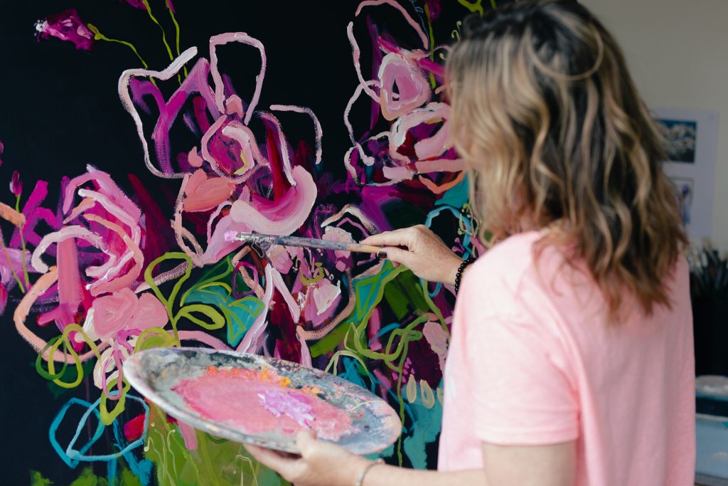 Melbourne artist Jen Shewring at work on a pink floral abstract painting for Bluethumb.