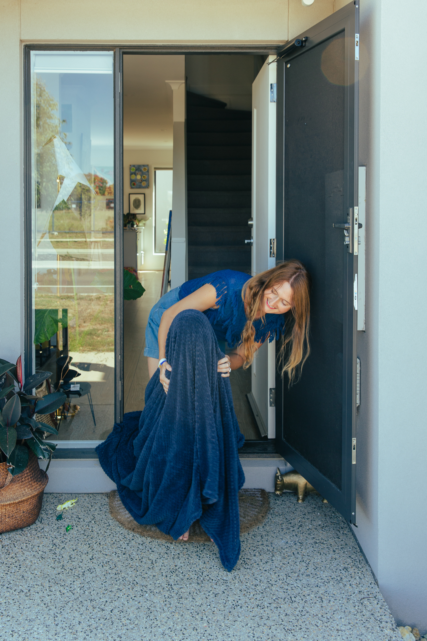 Female artist Kate Rogers in the doorway of her home