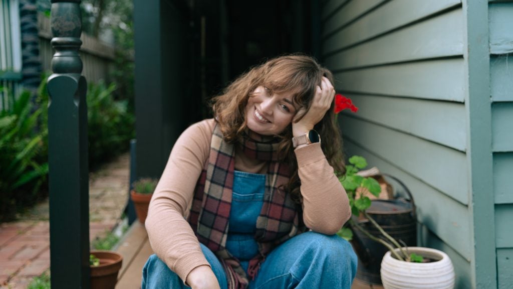 Woman sitting on edge of front porch