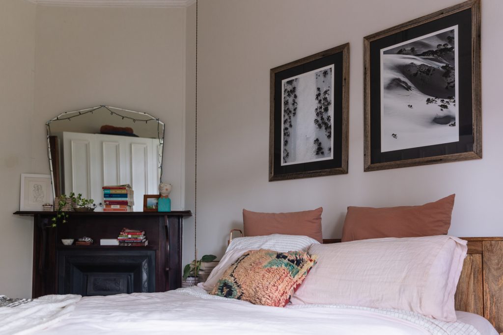 Two black and white photographs hang above bed