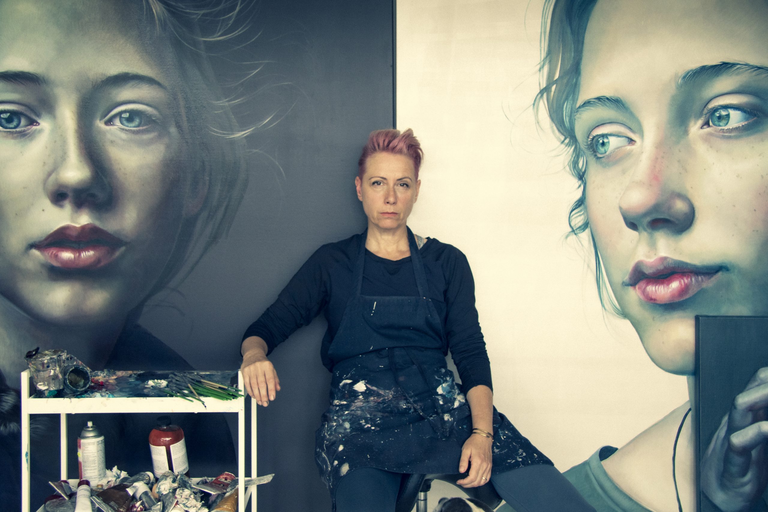 Kathrin Longhurst sitting between her artworks. 