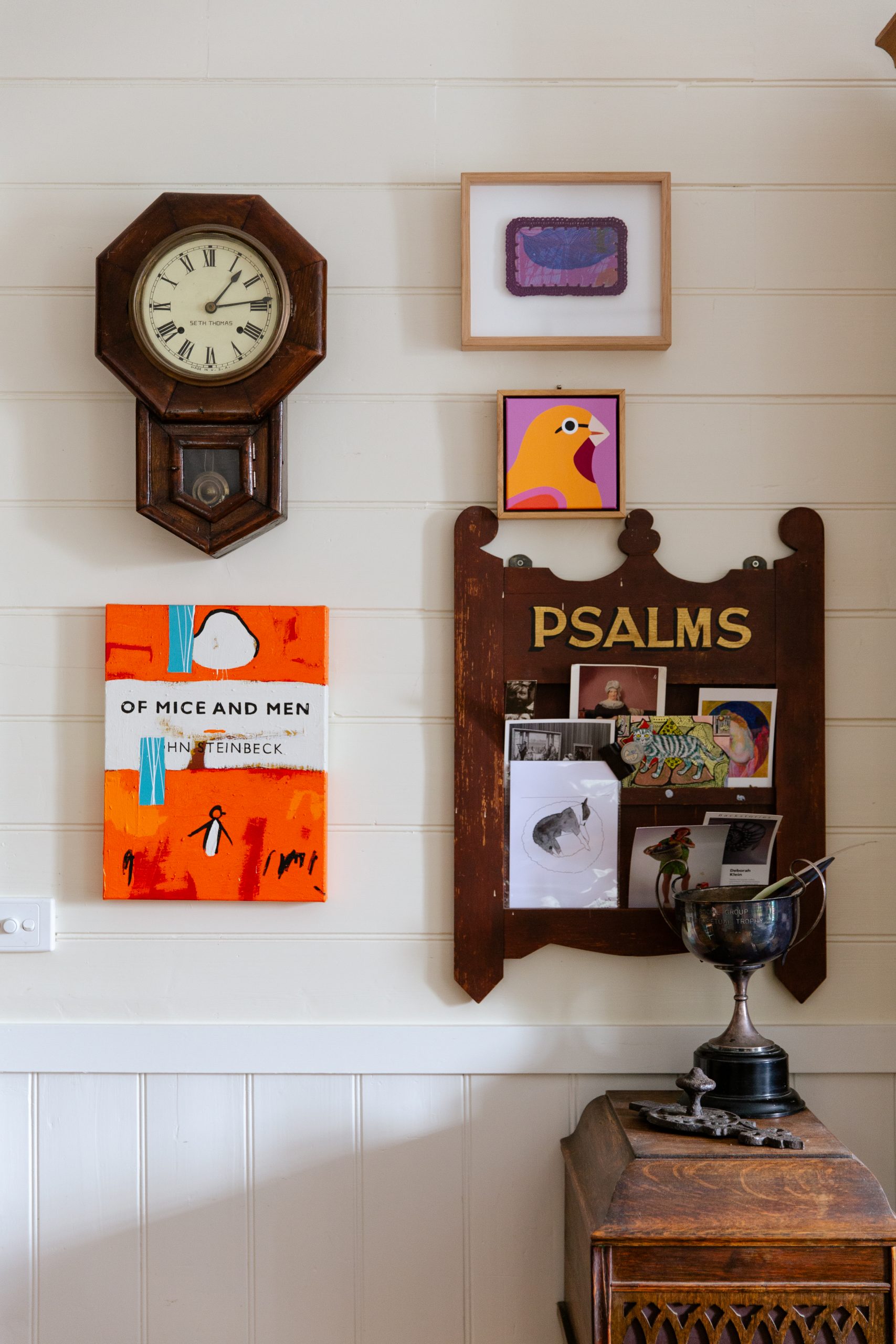 A wall in Alicia's home with artwork and antiques.