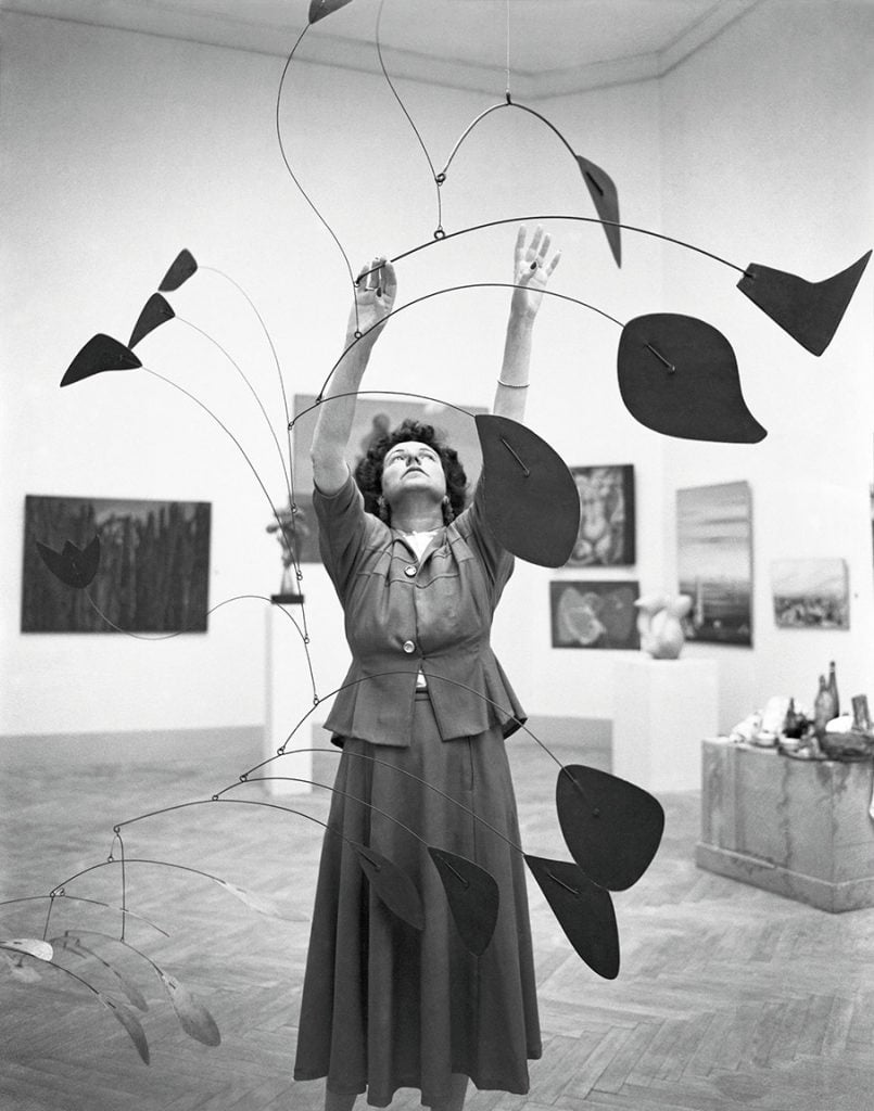 Peggy Guggenheim arranging Alexander Calder’s Arc of Petals. 