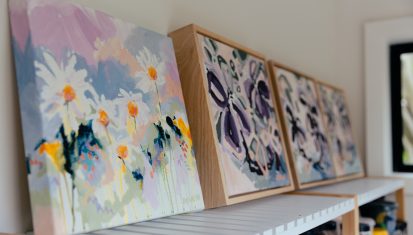 Small canvases lined up on shelf
